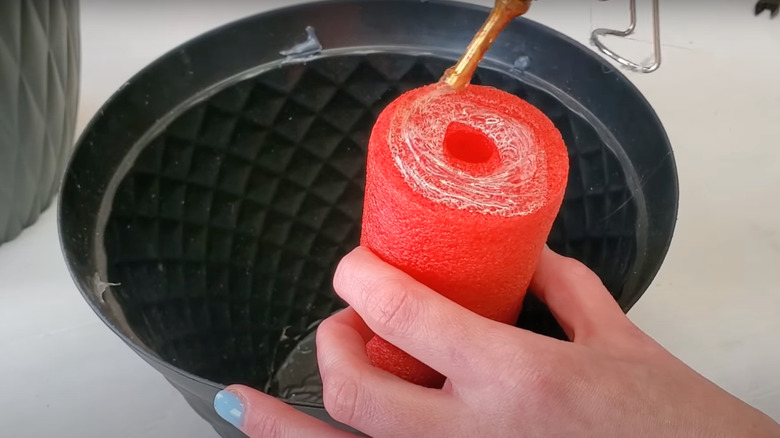 Person gluing noodle to planter