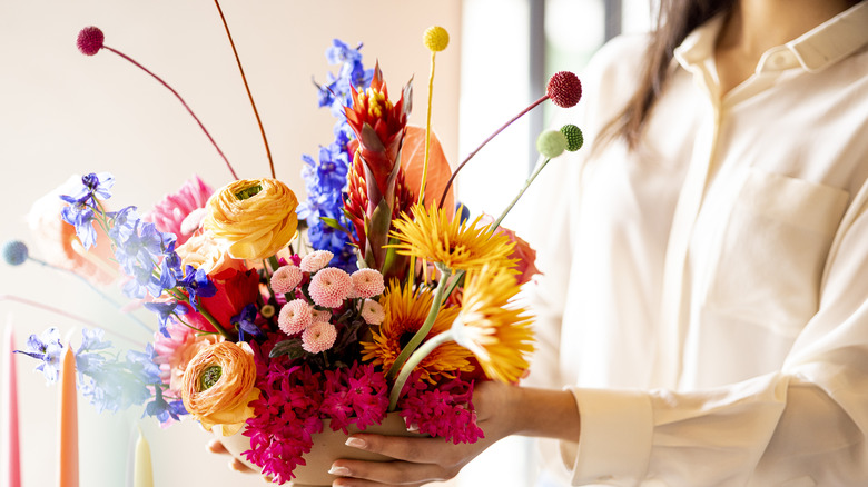 A woman carries a faux flower display.