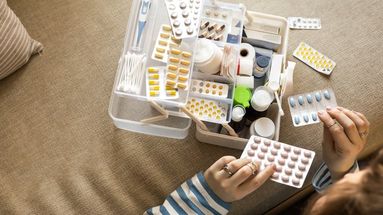 Person organizing emergency kit on couch in home