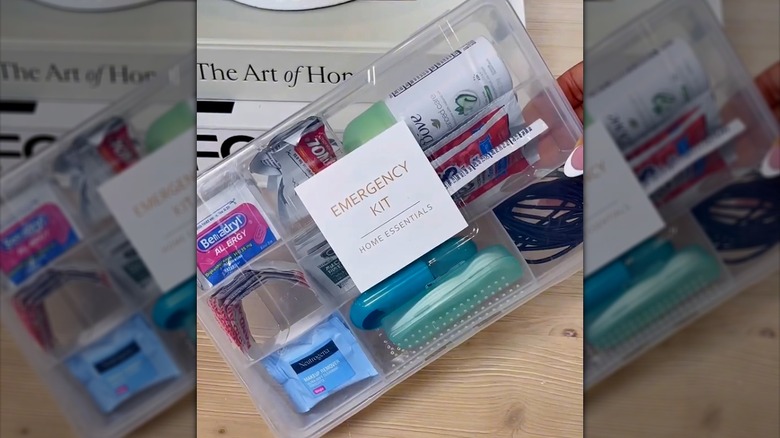 Labeled emergency kit in clear plastic bin filled with home essential items