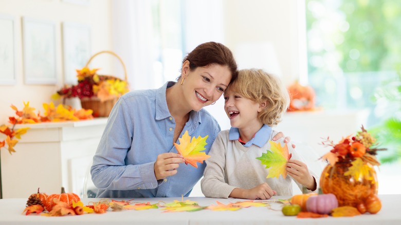 Mother and son holding leaves