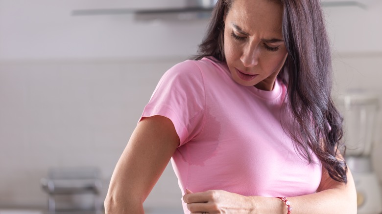 Woman looks at sweat stain