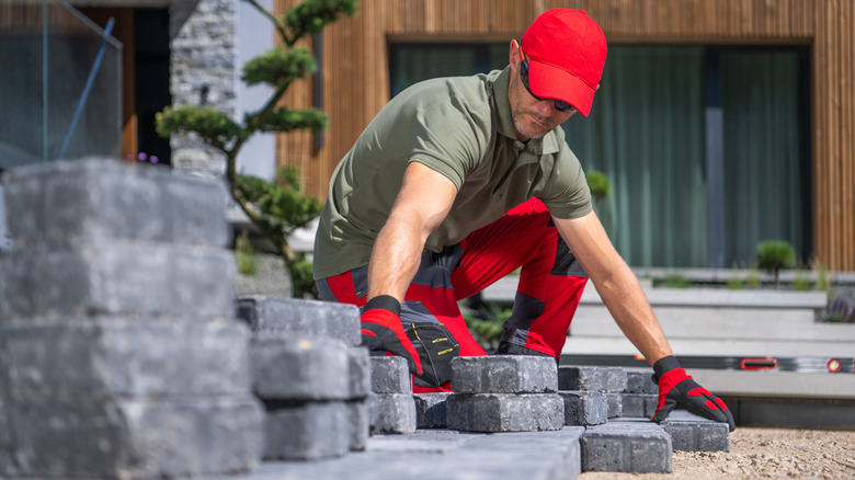 Man gathering dark pavers