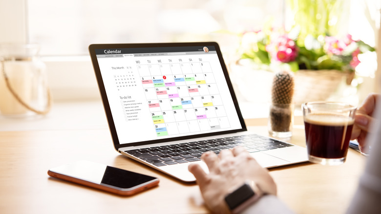 Person planning calendar events on laptop