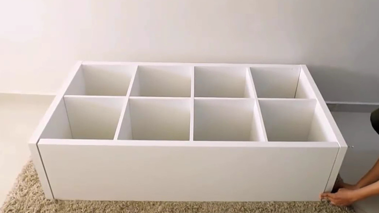 man constructing ikea kallax shelf 