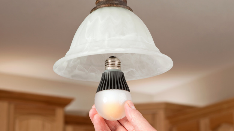 Person installing LED bulb 