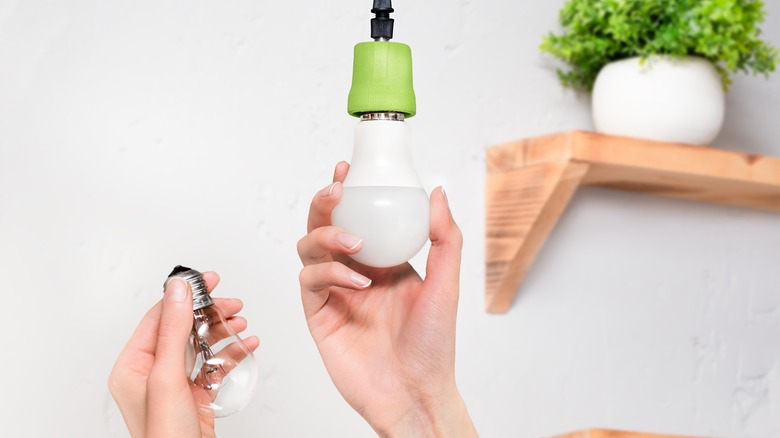 Woman installing LED bulb