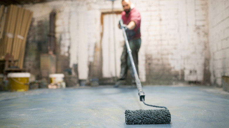 man rolling paint on floor