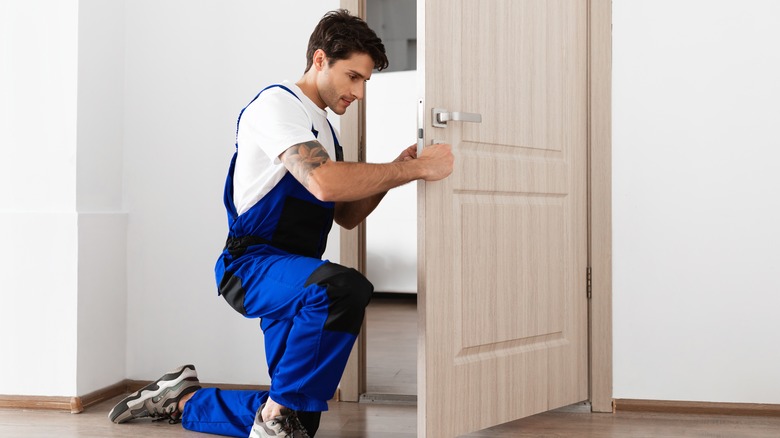man installing door lock