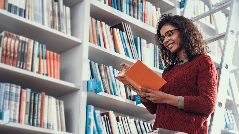 Woman reading on ladder