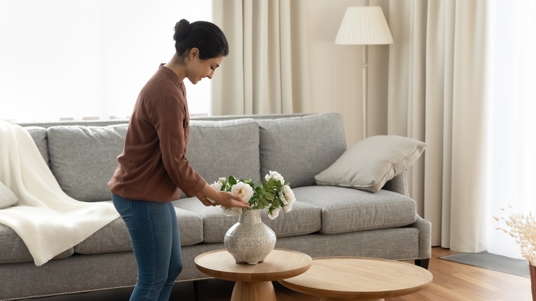 woman placing vase in living room
