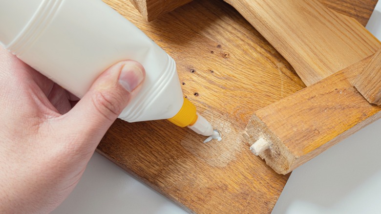 Applying wood glue to furniture