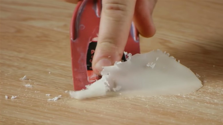 Plastic scraper scraping up wax