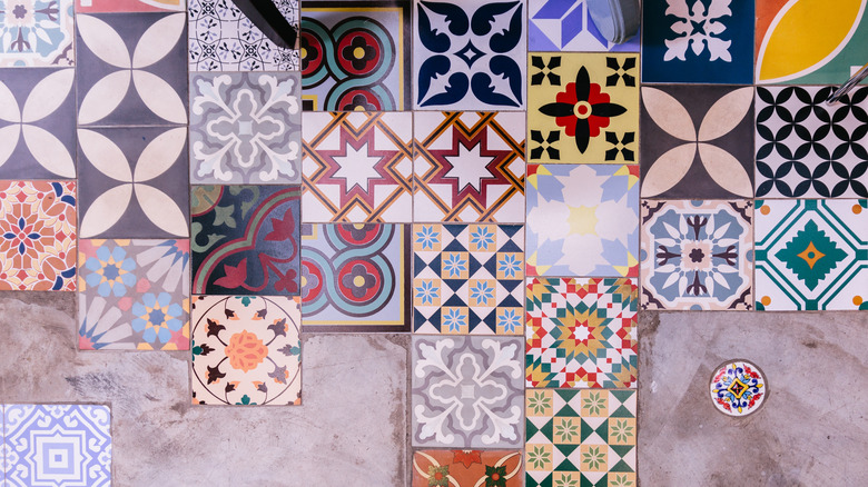 A collection of colorful patterned tiles are laid out on a floor