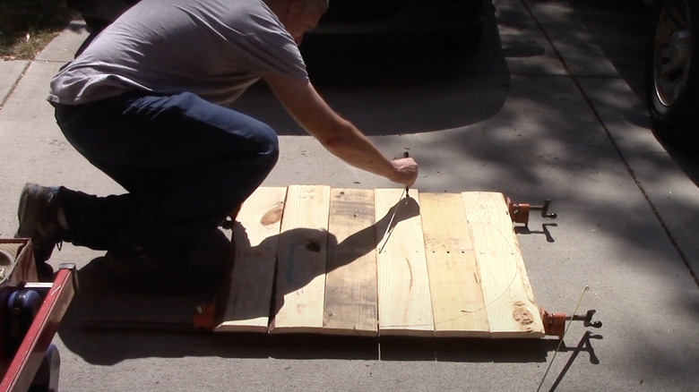 person drawing circle on wood 