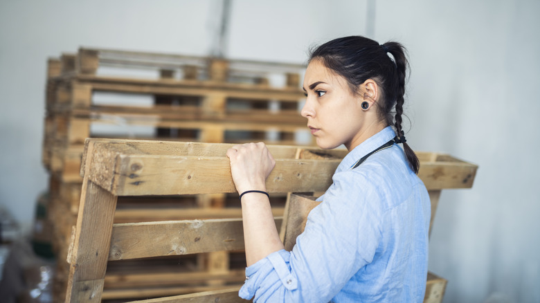 Woman holding wood pallet