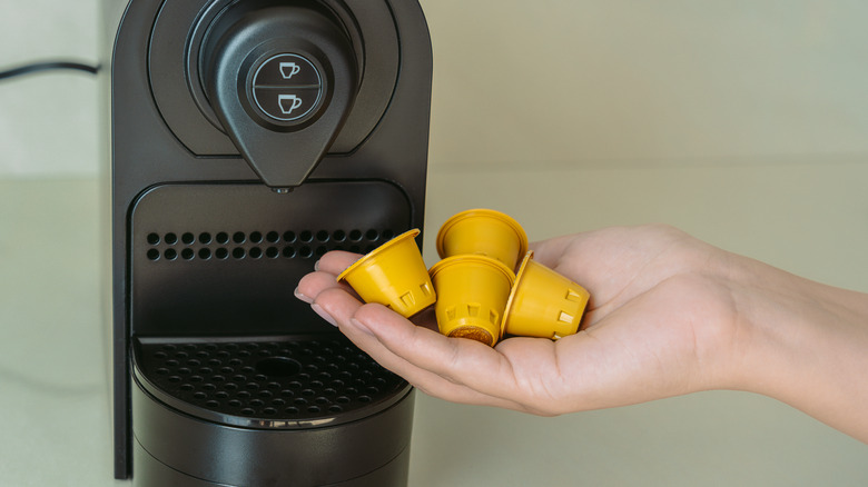 hand holding used coffee pods