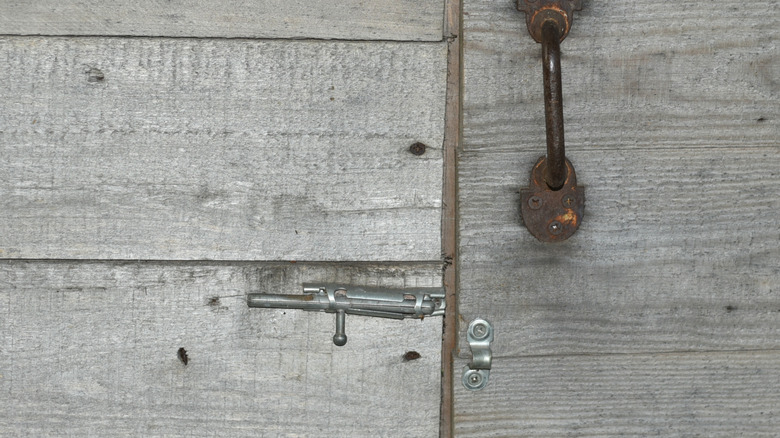 A misaligned latch resulting from a sagging gate is located on a fence.