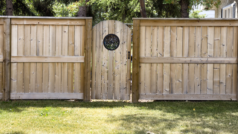 A properly hanging privacy fence gate is installed in a backyard