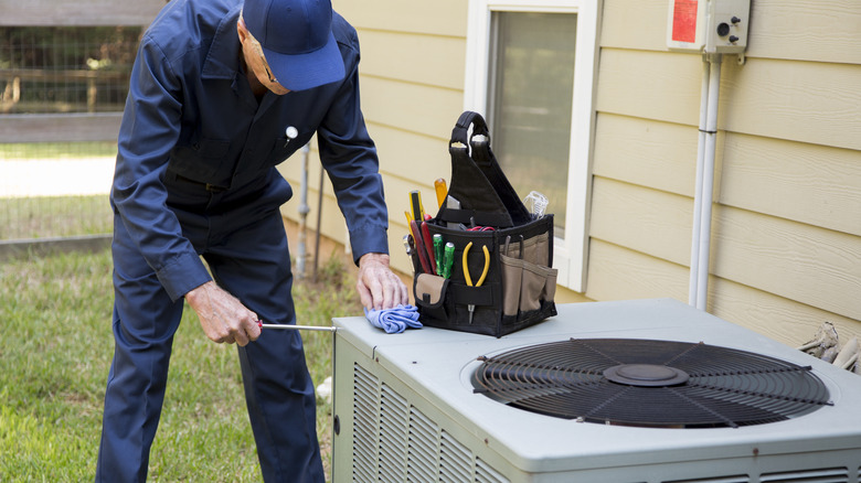 man inspecting HVAC system