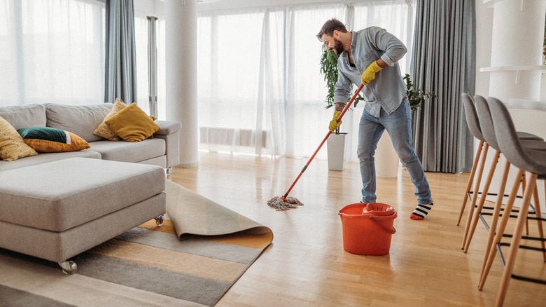 Man mopping hardwood floor