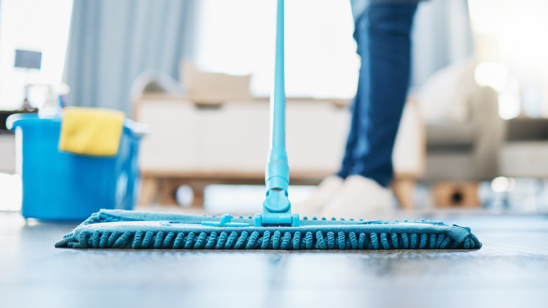 Person mopping wood floor in home