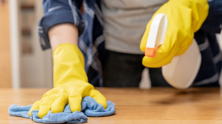 person cleaning wood with cloth 