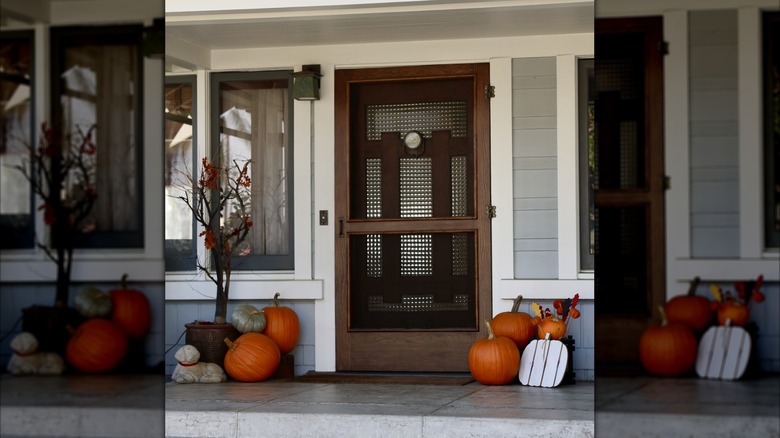 An exterior of a house that shows a wooden screen door