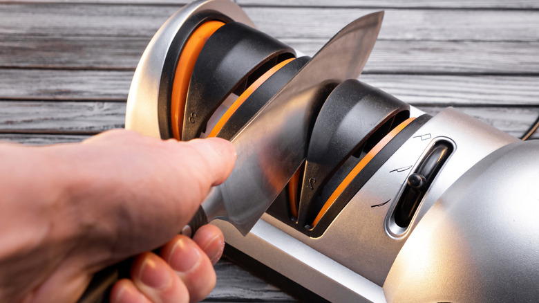 Man using an electric knife sharpener