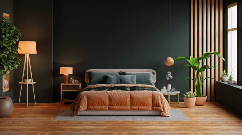 Bedroom with dark green walls and gold stained oak floors