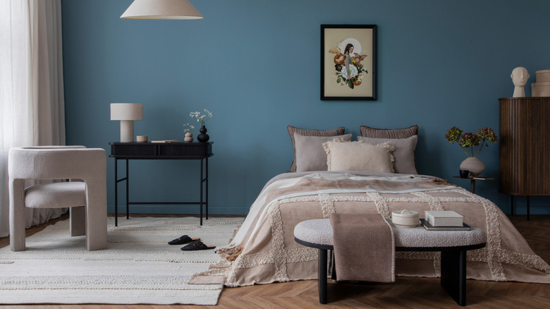 Bedroom with blue wall and neutral boho furniture