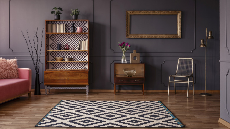 Living room area with purple wall and patterned rug