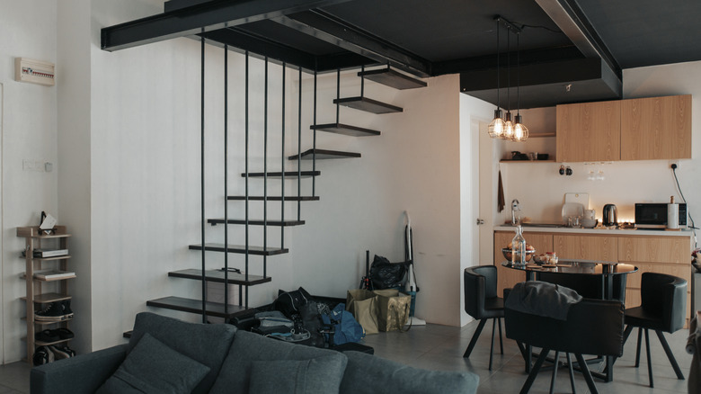 Loft with stairs with black ceilings and white walls.