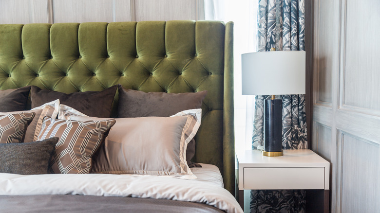 Upholstered green bed and nightstand