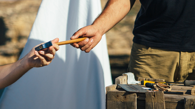 Hands grasping a hammer