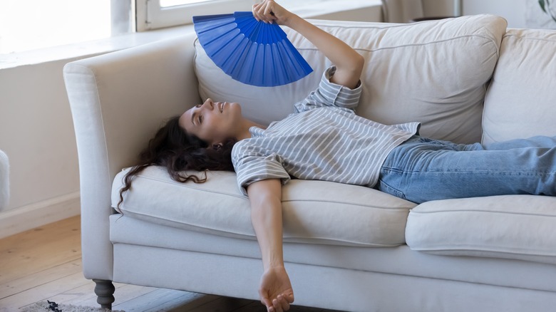 Person fanning themselves indoors