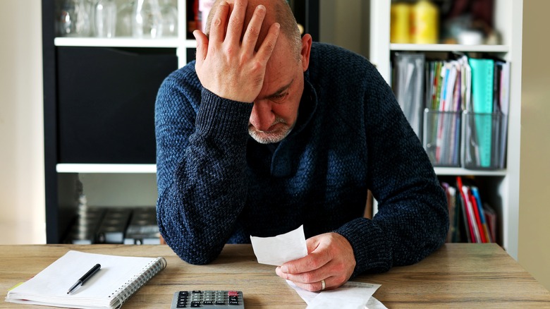 Man upset holding bill