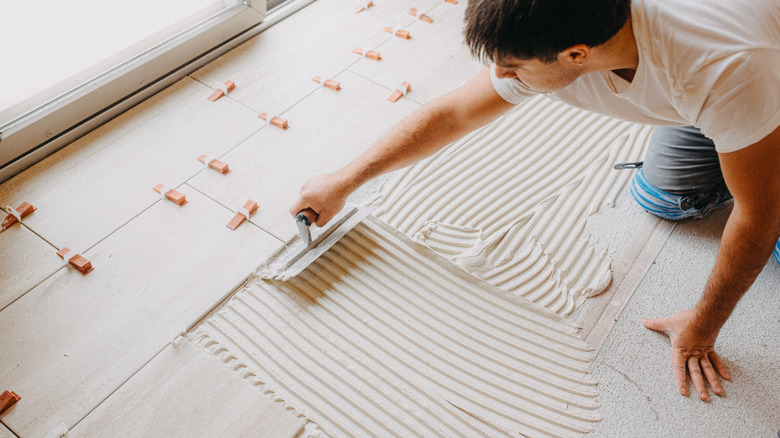 Person applying thin-set mortar for tile floor