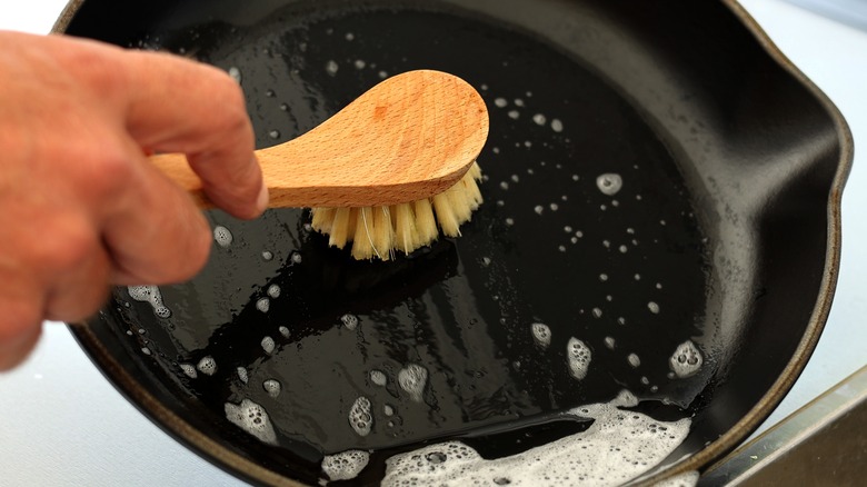 Person scrubbing a cast iron pan