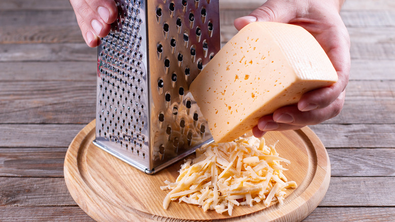 hands grating cheese