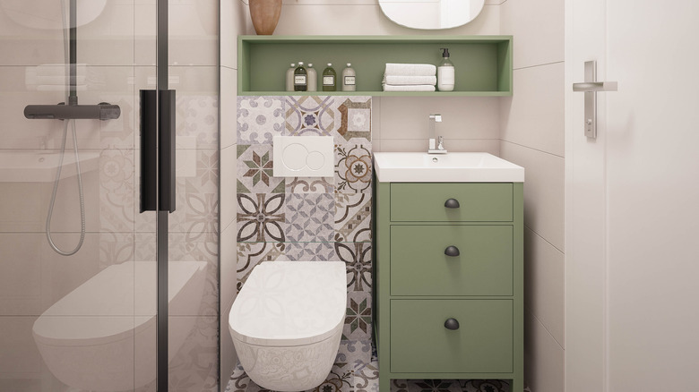 Elongated toilet and green cabinets