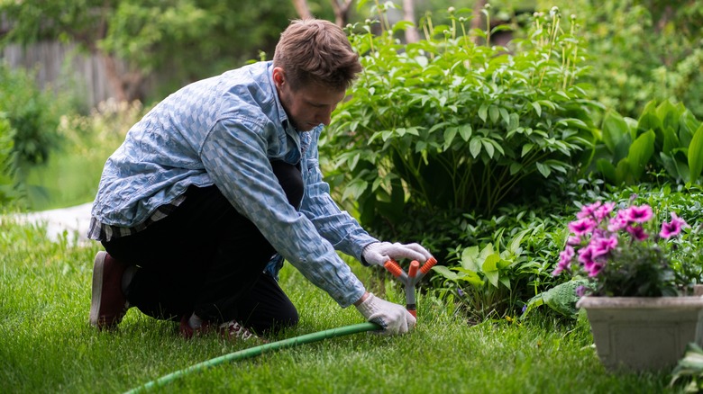 Man adjusting sprinkler