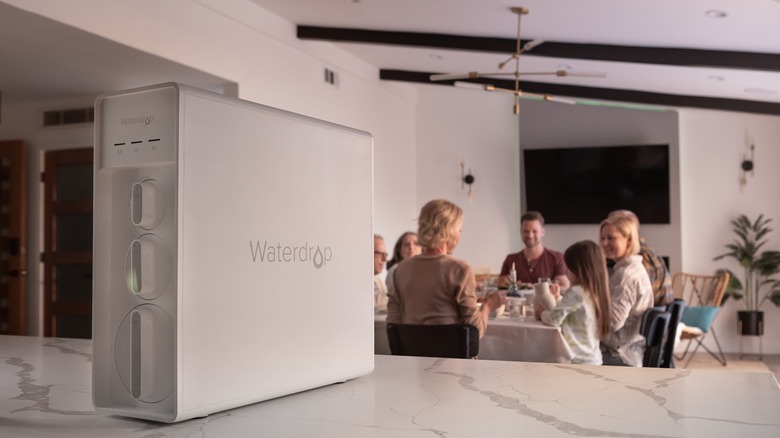 Waterdrop X12 filter system on counter, family around table