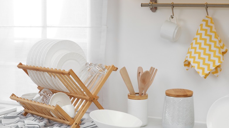 Bamboo dish rack holding white plates and glasses