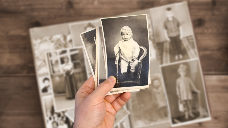 person holding old photographs