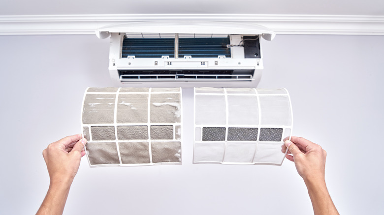 A person holds dirty and clean AC filters