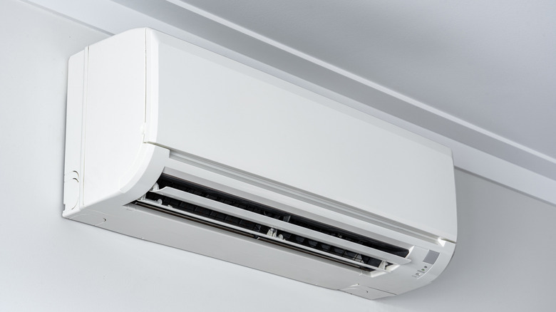 A white ductless mini split on a white wall mounted just below the ceiling