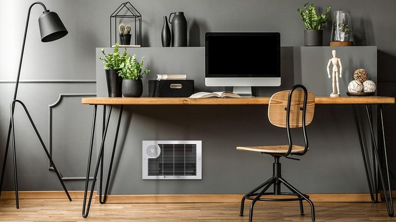 An electric wall heater under a desk