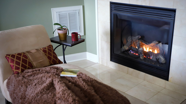 A gas fireplace near a chair