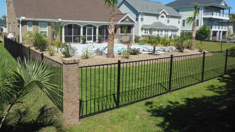 suburban house and pool with aluminum metal fencing